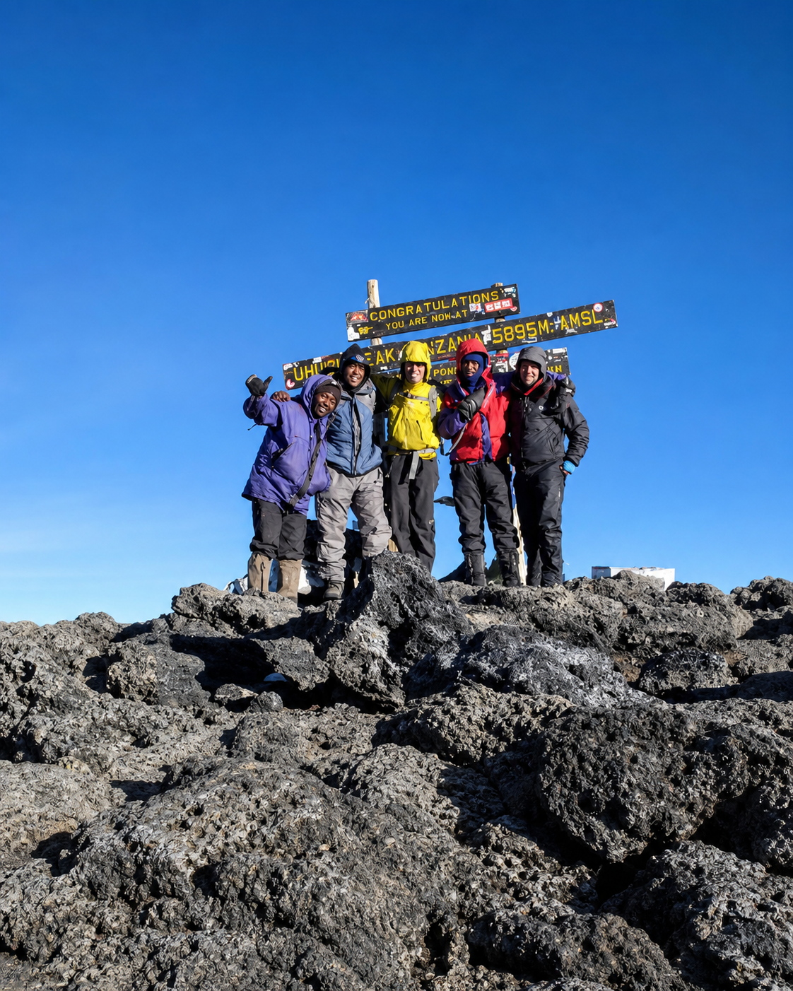 Climbers celebrating at the summit of Mount Kilimanjaro